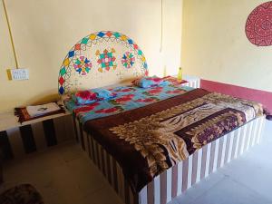 a bedroom with a bed with a colorful bedspread at Rann Kutch Resort in Dhordo