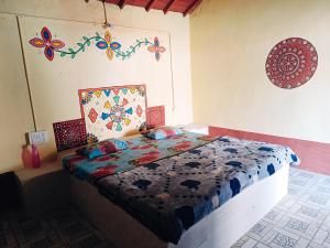 a bedroom with a bed with a quilt on it at Rann Kutch Resort in Dhordo