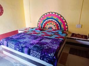 a bed with a colorful comforter in a room at Rann Kutch Resort in Dhordo