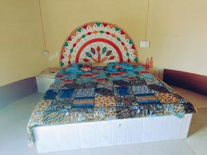 a bed with a colorful quilt on it in a room at Rann Kutch Resort in Dhordo