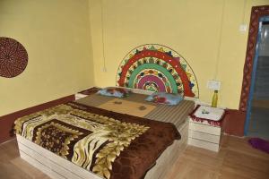 a bedroom with a bed with a mural on the wall at Rann Kutch Resort in Dhordo