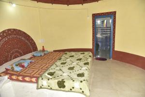 a bedroom with a bed with a blanket on it at Rann Kutch Resort in Dhordo