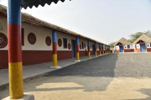 a row of buildings with colorful poles in front of them at Rann Kutch Resort in Dhordo