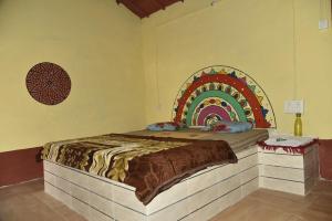 a bedroom with a bed with a rainbow on the wall at Rann Kutch Resort in Dhordo