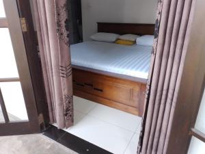 a bedroom with a bed and a window with curtains at COCO Rooms in Galle