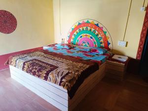 a bed with a colorful headboard in a room at Rann Kutch Resort in Dhordo