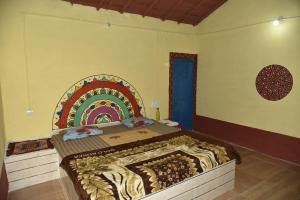 a bedroom with a large bed with a rainbow on the wall at Rann Kutch Resort in Dhordo