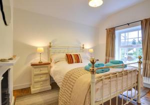 a bedroom with a white bed and a fireplace at Oswalds Cottage in Dinas Mawddwy
