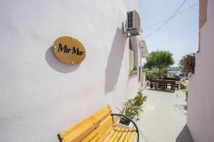 a wooden bench sitting next to a building with a sign at Mir Mar in Lampedusa