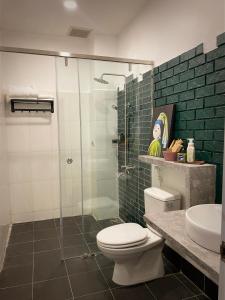 La salle de bains est pourvue de toilettes et d'une douche en verre. dans l'établissement Nhà mình Homestay, à Rạch Giá