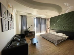 - une chambre avec un lit, un canapé et une table dans l'établissement Nhà mình Homestay, à Rạch Giá