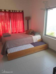 1 cama en un dormitorio con ventana roja en Villa Campestre con vista en Guadalajara