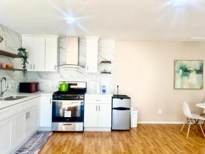 a kitchen with white cabinets and a stove top oven at 10% off! Chic Home with Expansive Backyard in San Mateo