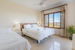 ein Schlafzimmer mit zwei Betten und einem großen Fenster in der Unterkunft 26 Front row penthouse golf and sea views Manilva Duquesa Andalusia in Manilva + 22 Fotos
