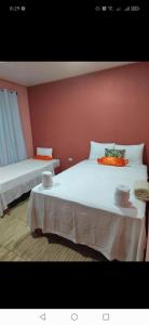 1 dormitorio con 2 camas y pared roja en Cabinas Agamy, en Tortuguero