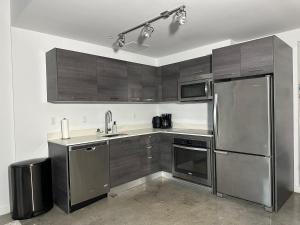 una cocina con armarios de madera y electrodomésticos de acero inoxidable en Pool Rooftop Luxury loft Miami Downtown, Brickell, en Miami