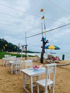 a group of tables and chairs on a beach at New Casamarc in Bentota