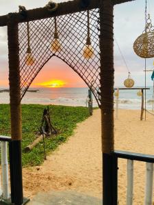 una vista su una spiaggia con il tramonto sullo sfondo di New Casamarc a Bentota