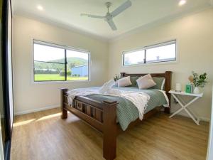 a bedroom with a bed and two windows at The Olive Abode - Atherton in Atherton