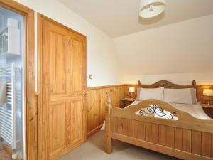 een slaapkamer met een houten bed en een houten deur bij 3 Bed in Ledbury 76423 