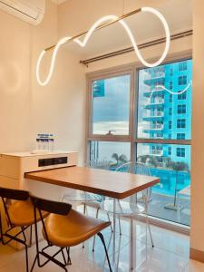 a dining room with a table and chairs and a large window at Bayshore 2 Residences in Manila