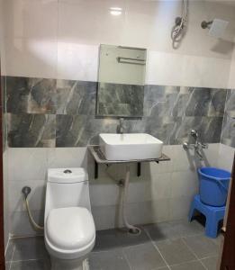 a bathroom with a white toilet and a sink at Supraja Cyber View in Hyderabad +35 photos
