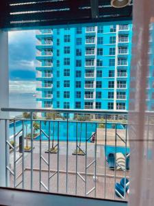 a balcony with a view of a large blue building at Bayshore 2 Residences in Manila