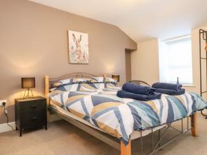 a bedroom with a bed with blue pillows on it at Rowarth in Pwllheli