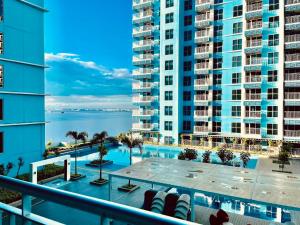 an apartment balcony with a swimming pool and buildings at Bayshore 2 Residences in Manila