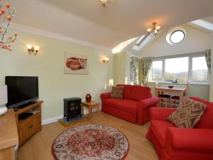 a living room with red furniture and a tv at 1 Bed in Ironbridge 73319 in Buildwas