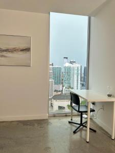 Pool Rooftop Luxury loft Miami Downtown, Brickell في ميامي: غرفة بيضاء مع طاولة وكرسي ونافذة