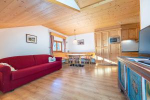 a living room with a red couch and a table at Week End Senoner in Selva di Val Gardena