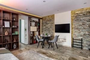 a living room with a table and chairs and a brick wall at Sika Royal Central Apartment in Arad