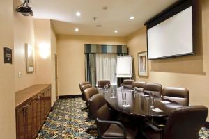 a conference room with a table and chairs and a screen at Staybridge Suites Corpus Christi, an IHG Hotel in Corpus Christi
