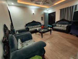 Sala de estar con sofás y mesa de centro en Daily BASIS 3-BEDROOMS FAMILY APARTMENT, en Islamabad