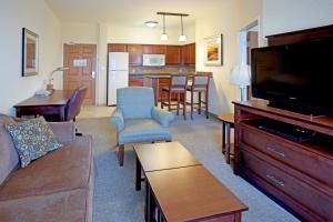 Staybridge Suites Corpus Christi, an IHG Hotel في كوربوس كريستي: غرفة معيشة مع أريكة وتلفزيون