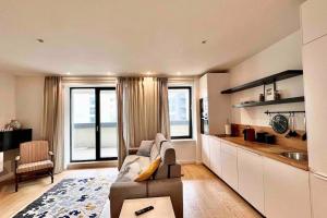 a living room with a couch and a kitchen at Nordic Oasis Luxury 1 bedroom Aviatiei Tower in Bucharest