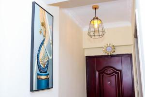 een hal met een paarse deur en een kroonluchter bij Epic Home By Edmor Suite in Nairobi