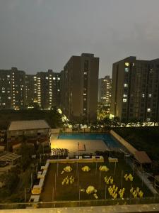 a swimming pool with umbrellas in a city at night at Weekend Address in Surat