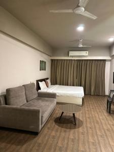 ein Wohnzimmer mit einem Sofa und einem Bett in der Unterkunft Weekend Address in Surat