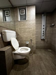 a bathroom with a toilet and a shower at Weekend Address in Surat