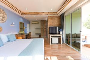Arkbar Beach Club في شاطئ تشاوينغ: غرفة نوم بسرير كبير وتلفزيون