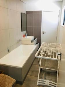 ein Badezimmer mit einer Badewanne, einem Waschbecken und einem Spiegel in der Unterkunft Executive 2 bedroom Apartment At East Legon in Accra