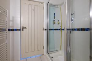 uma casa de banho com um chuveiro e uma porta de vidro em Paddock House em Windermere
