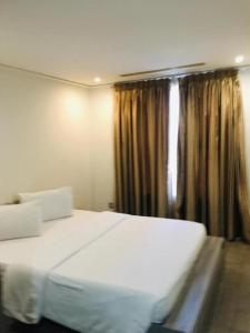 a bedroom with a large white bed and a window at Incredible one bedroom space at East Legon in Accra