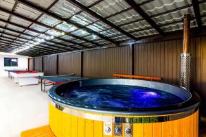 uma grande banheira de hidromassagem numa sala com mesas de pingue-pongue em Agropensiunea DarDen em Baia de Fier