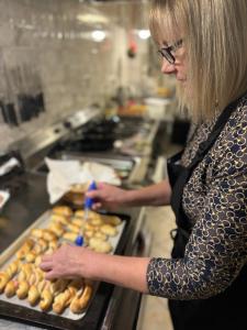 a woman is making donuts in a bakery at Hotel Garni Expo in Banská Bystrica