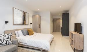 Luxurious loft space Available في آكرا: غرفة نوم بسرير وتلفزيون وأريكة