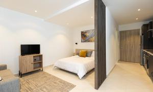 sypialnia z łóżkiem i telewizorem z płaskim ekranem w obiekcie Luxurious loft space Available w Akrze