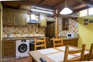 een keuken met een wasmachine en een tafel en stoelen bij La casita de la Senda 